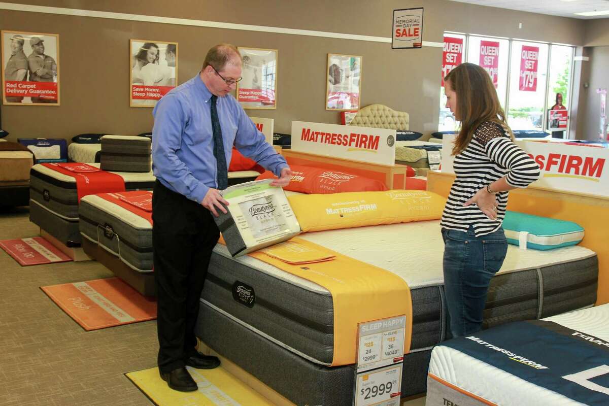 Ben Wilson, area manager for Mattress Firm, helps customer Lisa Ellingsen at a Mattress Firm. Mattress Firm CEO Ken Murphy said in a statement the company is planning to “revitalize” its stores this year with new products from manufacturers including Serta Simmons.