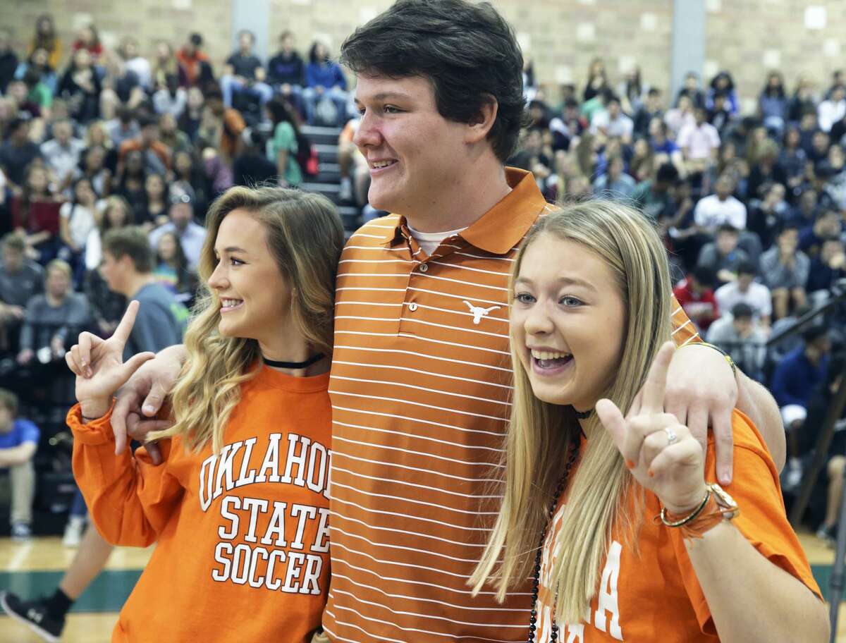 Oklahoma State soccer signees Lauren Anderson (left) and Taylor Olson have some fun posing for photos with UT football signee Derrick Kerstetter as Reagan High School athletes sign scholarship papers on national signing day, February 1, 2017.