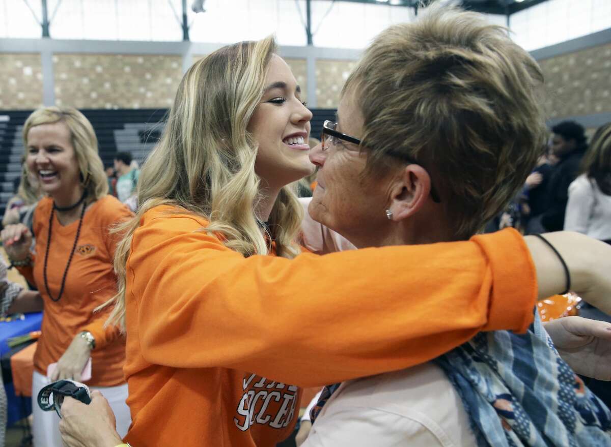 Lauren Anderson Hugs her coach Frnakie Whitlock as Reagan High School athletes sign scholarship papers on national signing day, February 1, 2017. Anderson will play soccer at OKlahoma State.