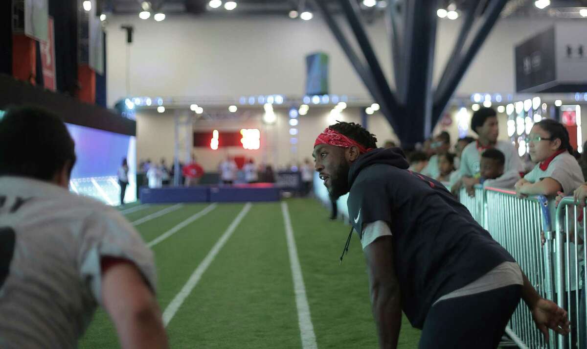 Akeem Hunt helps out area school kids participate in a timed forty-yard dash during the NFL Experience as part of the NFL Play 60 Kids' Day on Wednesday, Feb. 1, 2017, in Houston.