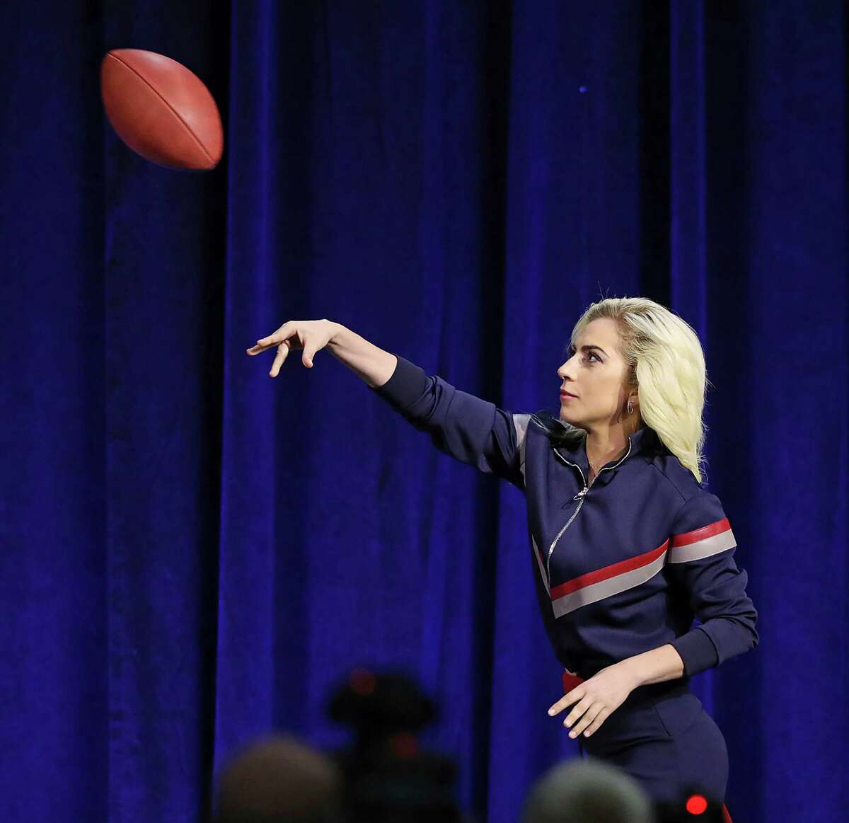 Lady Gaga throws her official game ball into the crowd Lady during an NFL football news conference about the halftime show for Super Bowl 51, Thursday, Feb. 2, 2017, in Houston. (Curtis Compton/Atlanta Journal-Constitution via AP)