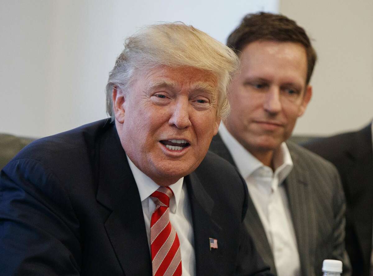 FILE - In this Wednesday, Dec. 14, 2016, file photo, PayPal founder Peter Thiel, right, listens as then President-elect Donald Trump speaks during a meeting with technology industry leaders at Trump Tower in New York. Thiel was able to gain New Zealand citizenship in 2011 despite never having lived in the country because a top lawmaker decided his entrepreneurial skills and philanthropy were valuable, documents reveal. Thiel didn't even have to leave California to become a new member of the South Pacific nation. (AP Photo/Evan Vucci, File)