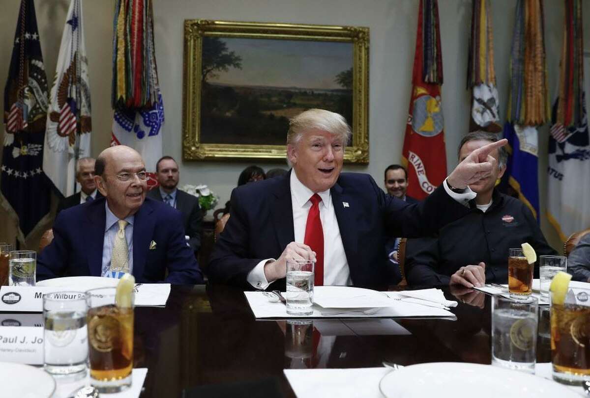 President Donald Trump, flanked by Commerce Secretary-designate Wilbur Ross, left, and Harley Davidson President and CEO Matt Levatich talks to media before a lunch meeting with Harley Davidson executives and union representatives in the Roosevelt Room of the White House in Washington, Thursday, Feb. 2, 2017. (AP Photo/Carolyn Kaster)