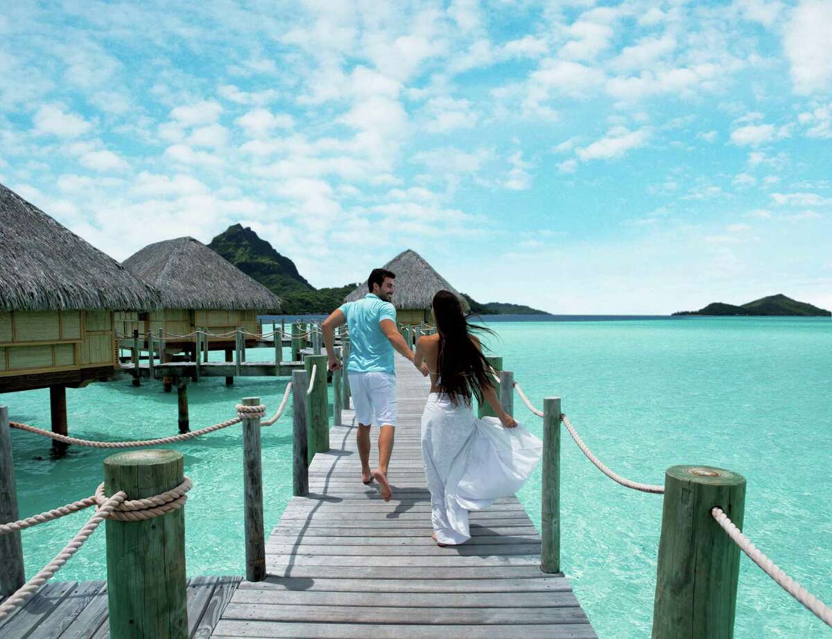 The thatched-roof bungalows over crystal blue waters in Bora Bora help make this a honeymooners’ delight.