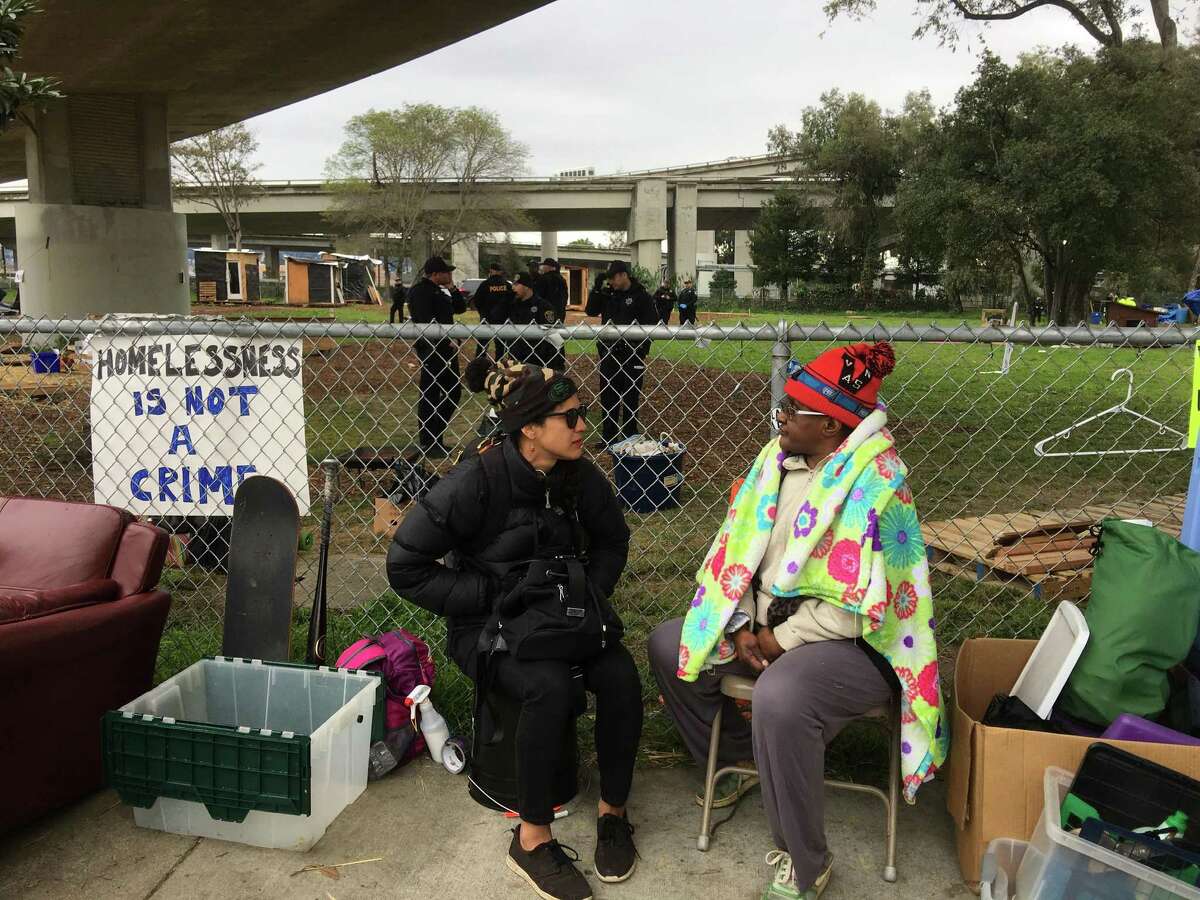 Nancy Mitchell (right) talks with Rae, who only gave her first name, after she was told to leave a park Thursday morning that had been turned into a village for the homeless.