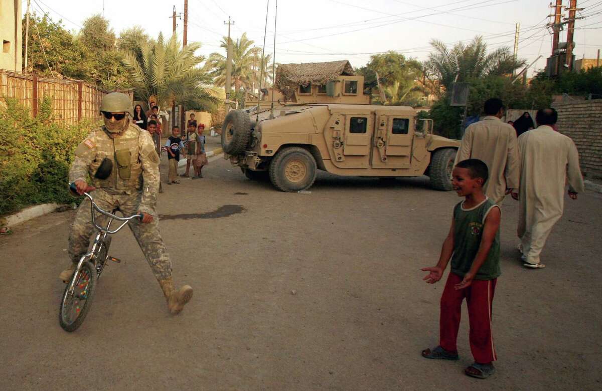 An interpreter for the U.S. Army rides a bicycle in the Amariyah neighborhood of west Baghdad, Iraq on Monday, Aug. 6, 2007. (AP Photo/Petr David Josek)