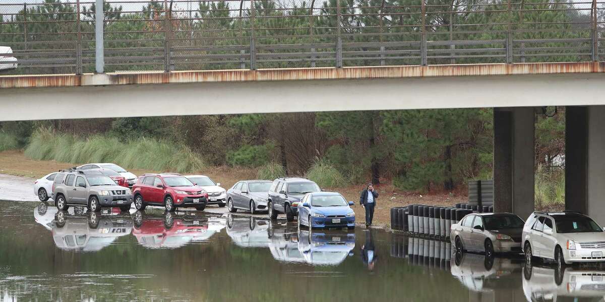 A motorist walks back to his flooded vehicle near Binz and Texas 288 after area flooding caused problemson Jan. 18. Fixing Houston's flood-prone areas could receive a boost from increases in infrastructure spending nationally.