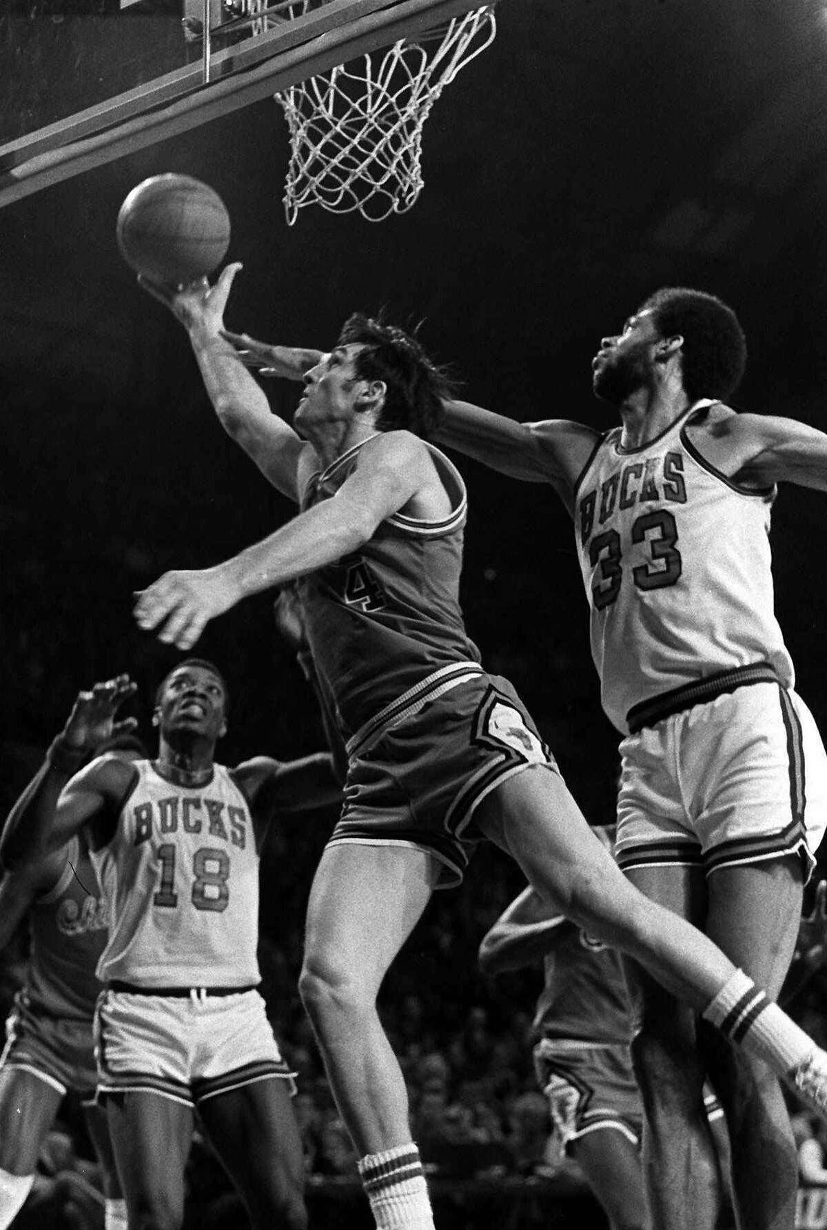 Chicago Bulls’ Jerry Sloan (4) glides in for a layup on the Milwaukee Bucks’ Kareem Abdul-Jabbar (33) on Feb. 16, 1974.