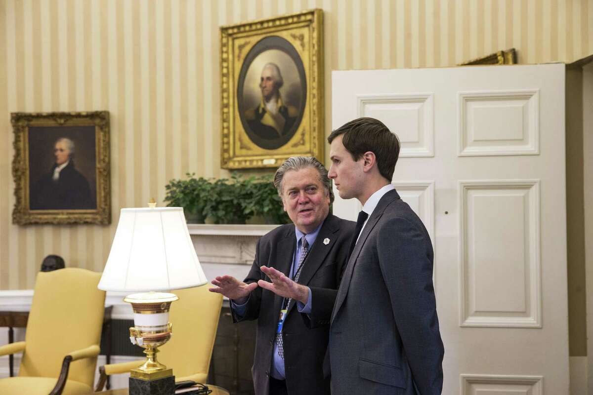 Stephen Bannon (left), President Donald Trump’s chief strategist, and Jared Kushner, a senior adviser, speak Friday as the president signs an executive order calling for a rewriting of major provisions of the 2010 Dodd-Frank Act.