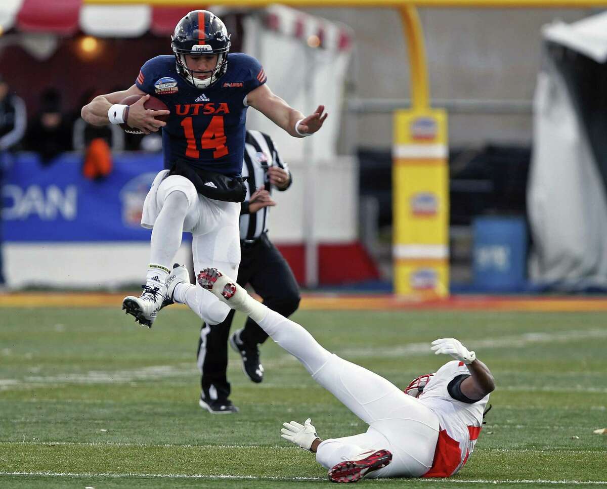 UTSA quarterback Dalton Sturm (14) leaps over New Mexico safety Ryan Santos to pick up extra yardage during the second half of the New Mexico Bowl NCAA college football game in Albuquerque, N.M., Saturday, Dec. 17, 2016. (AP Photo/Andres Leighton)