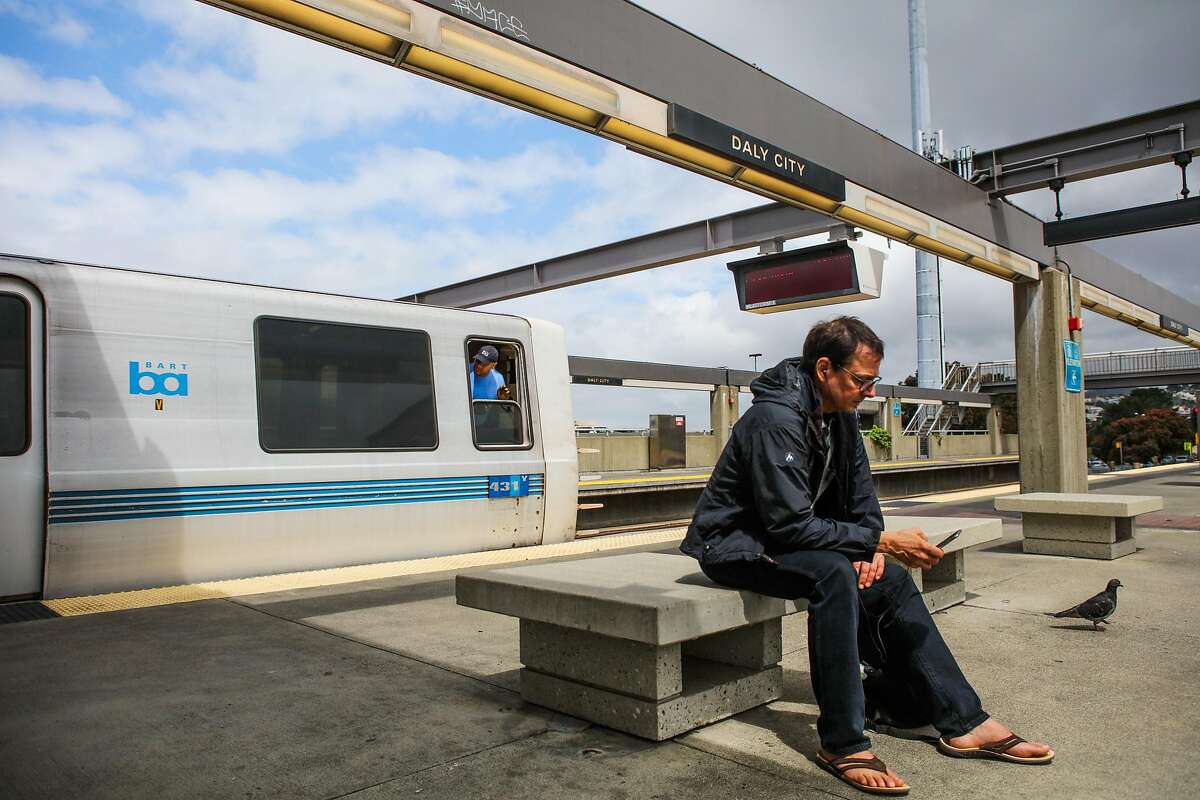 A man checks his phoneat the Daly City BART station.