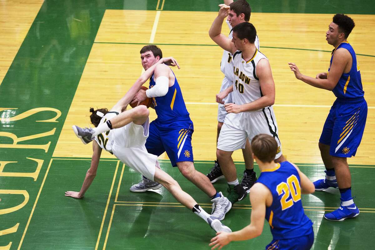 Midland's Martin Money attempts the shot while being fouled by Dow's Zachary Chichester in a game at H. H. Dow High School on Friday.