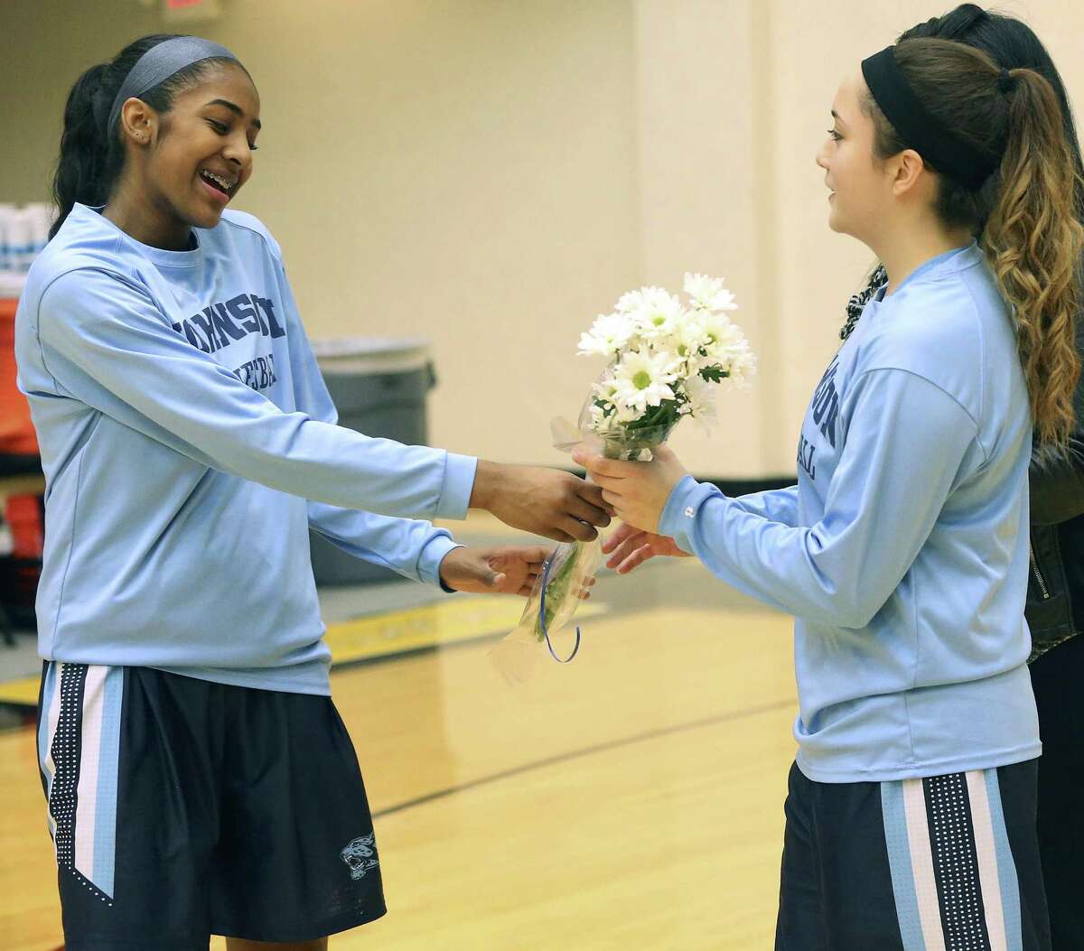 Deja Kelly hands flowers to her cousin Megan Valdez-Crader before game time as Johnson plays Lee in girls basketball at Littleton Gym on Feb. 3, 2017.