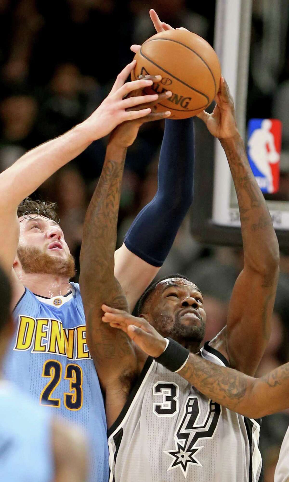 Denver Nuggets’ Jusuf Nurkic and the Spurs’ Dewayne Dedmon grab for a loose ball during first half action on Feb. 4, 2017 at the AT&T Center.