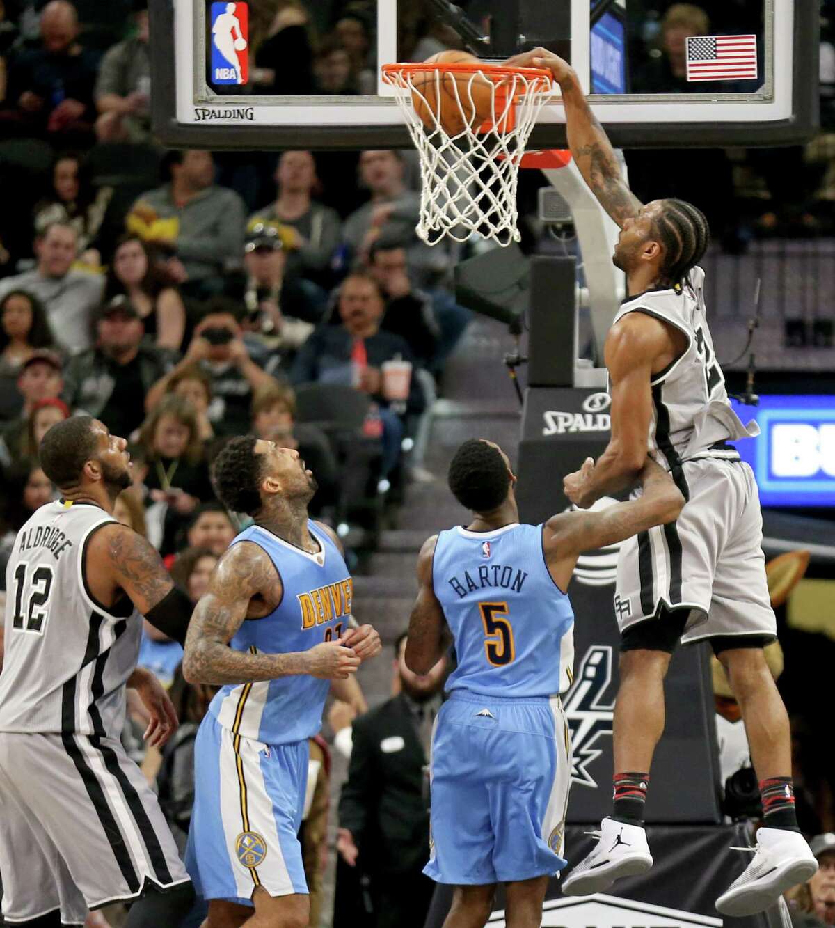 San Antonio Spurs' Kawhi Leonard dunks over Denver Nuggets?• Will Barton as San Antonio Spurs' LaMarcus Aldridge (from left) and Denver Nuggets?• Wilson Chandler look on during second half action Saturday Feb. 4, 2017 at the AT&T Center. The Spurs won 121-97.