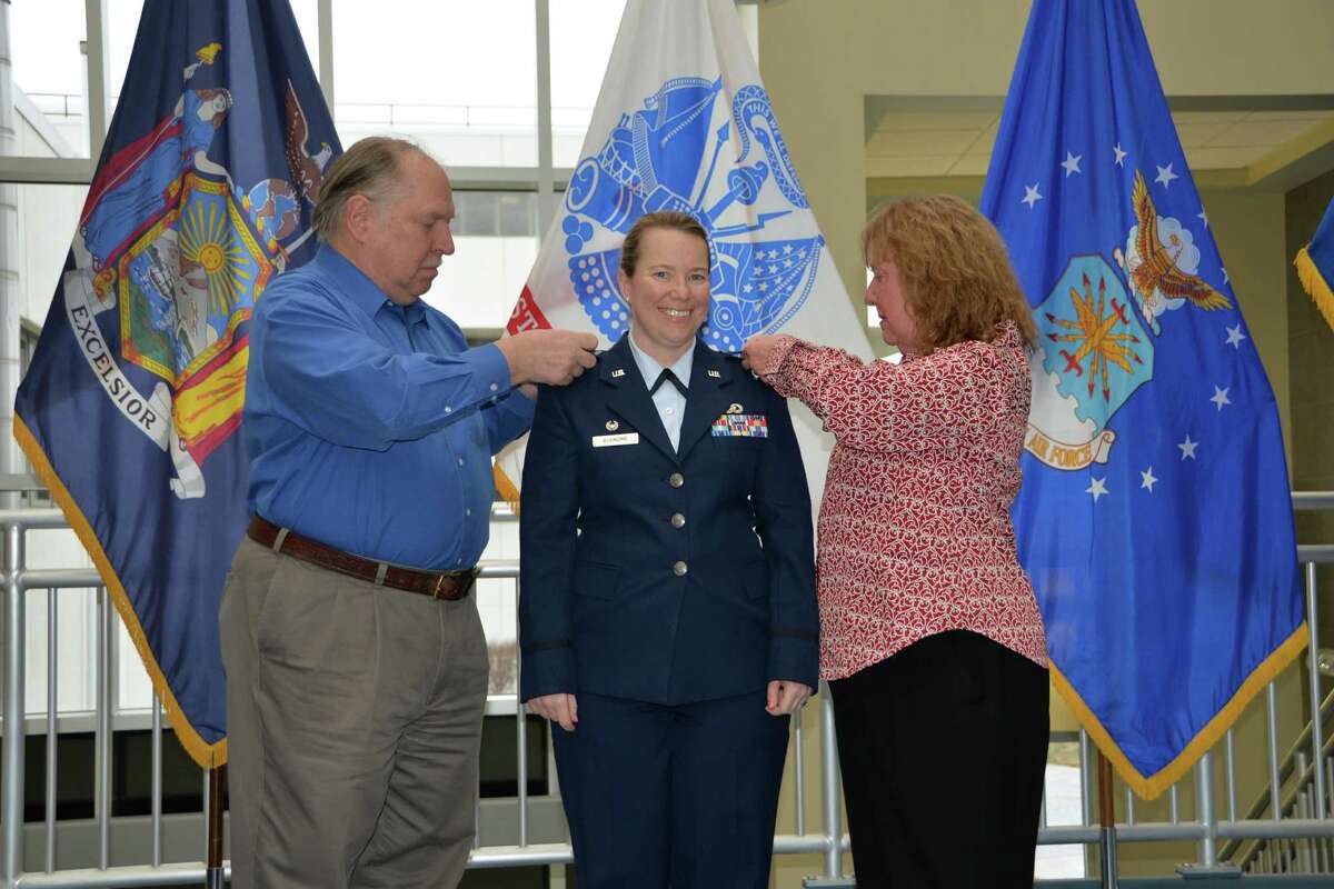 Lt. Col. Michelle Buonome smiles as her father Joe Haus and her mother Jean Haus pin on her new rank during promotion ceremonies.