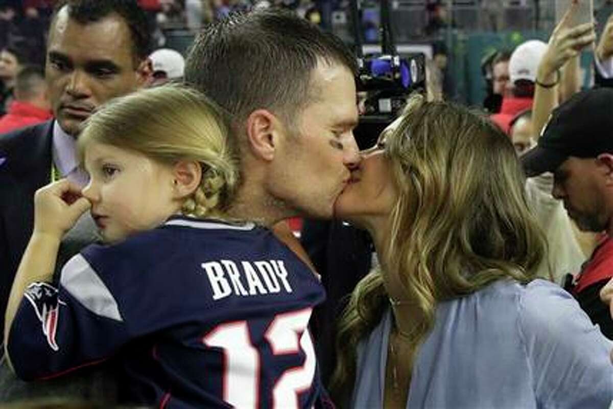 Tom Brady de los Patriots de Nueva Inglaterra besa a su esposa Gisele Bundchen tras la victoria sobre los Falcons de Atlanta en el Super Bowl, el domingo 5 de febrero de 2017. A la izquierda, su hija Vivian. (AP Foto/Patrick Semansky)