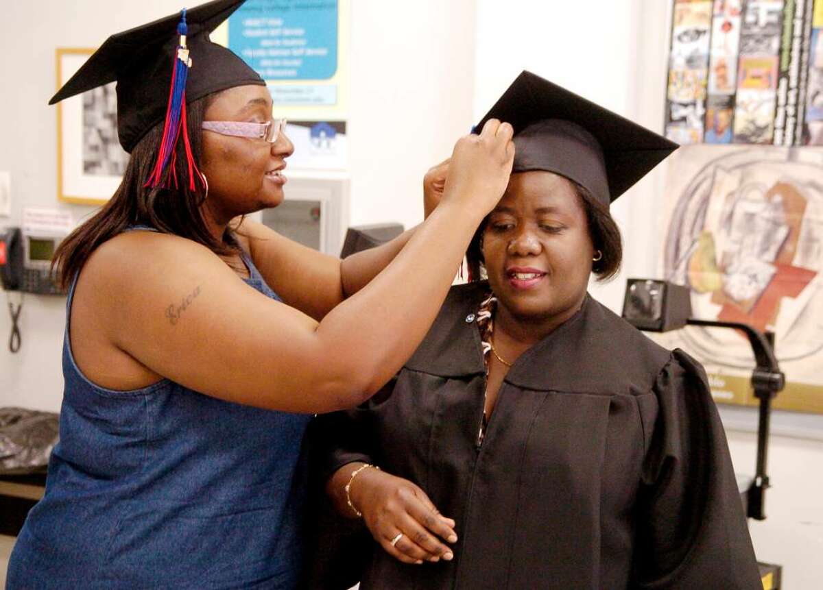 Erica Sherman helps Mimose Brice pin her cap getting ready for their graduation, both with degrees in Respiratory Care from Norwalk Community College in Norwalk, Conn. on Thursday May 20, 2010.