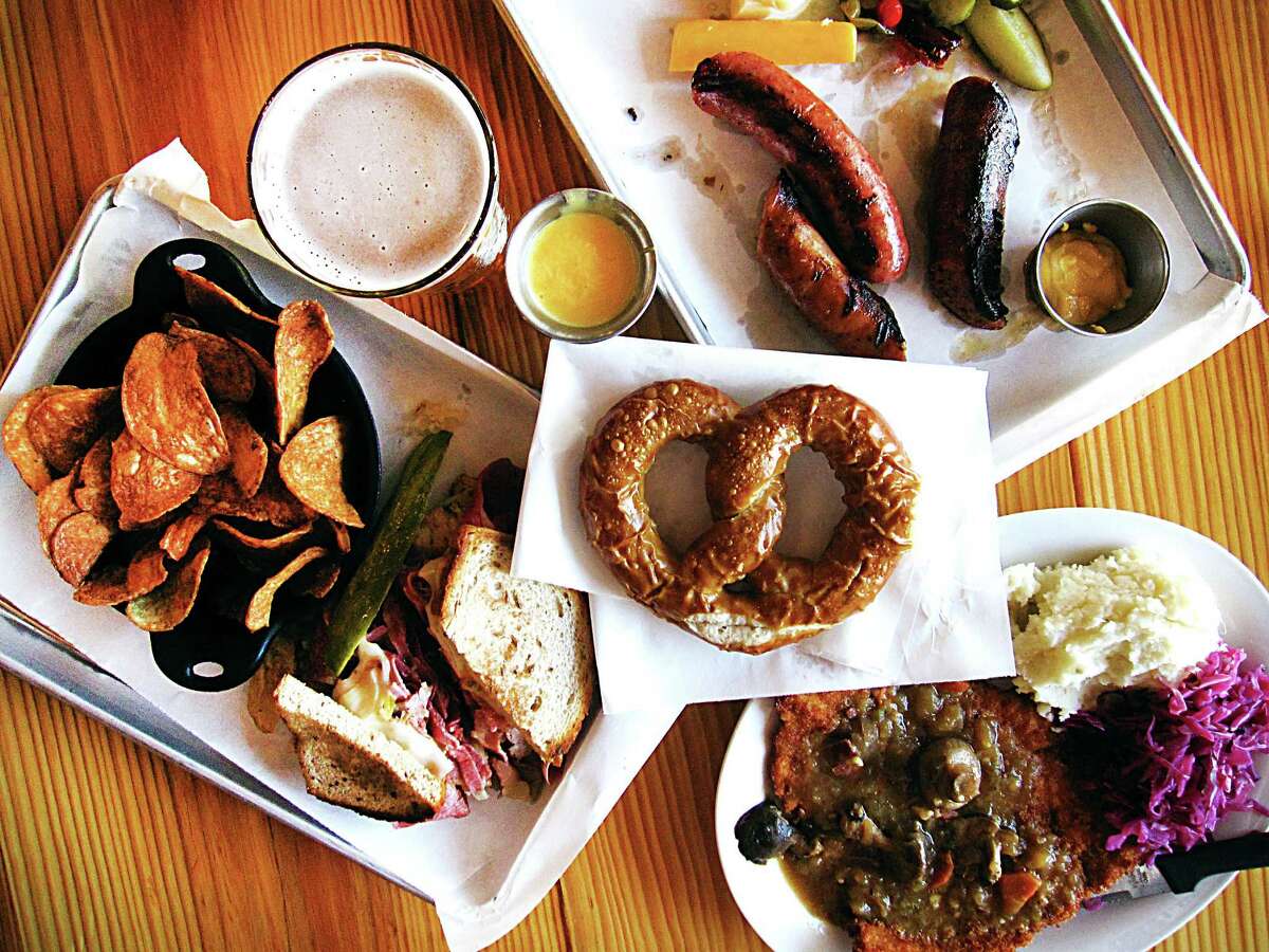 An array of dishes from the new Krause's Cafe in New Braunfels. Clockwise from left: A Reuben sandwich with house-fried potato chips, a sausage sampler with pickles and cheese, jägerschnitzel with mushroom gravy, mashed potatoes and red cabbage and a pretzel with beer cheese (center).