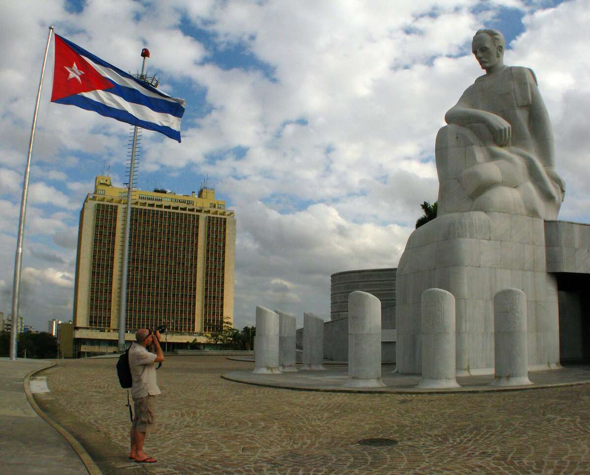 A tourist takes a photo of the Jose Marti statue in Plaza de la Revolucion. The museum tower behind the statue is 358 feet tall, the highest point in Havana, Cuba.