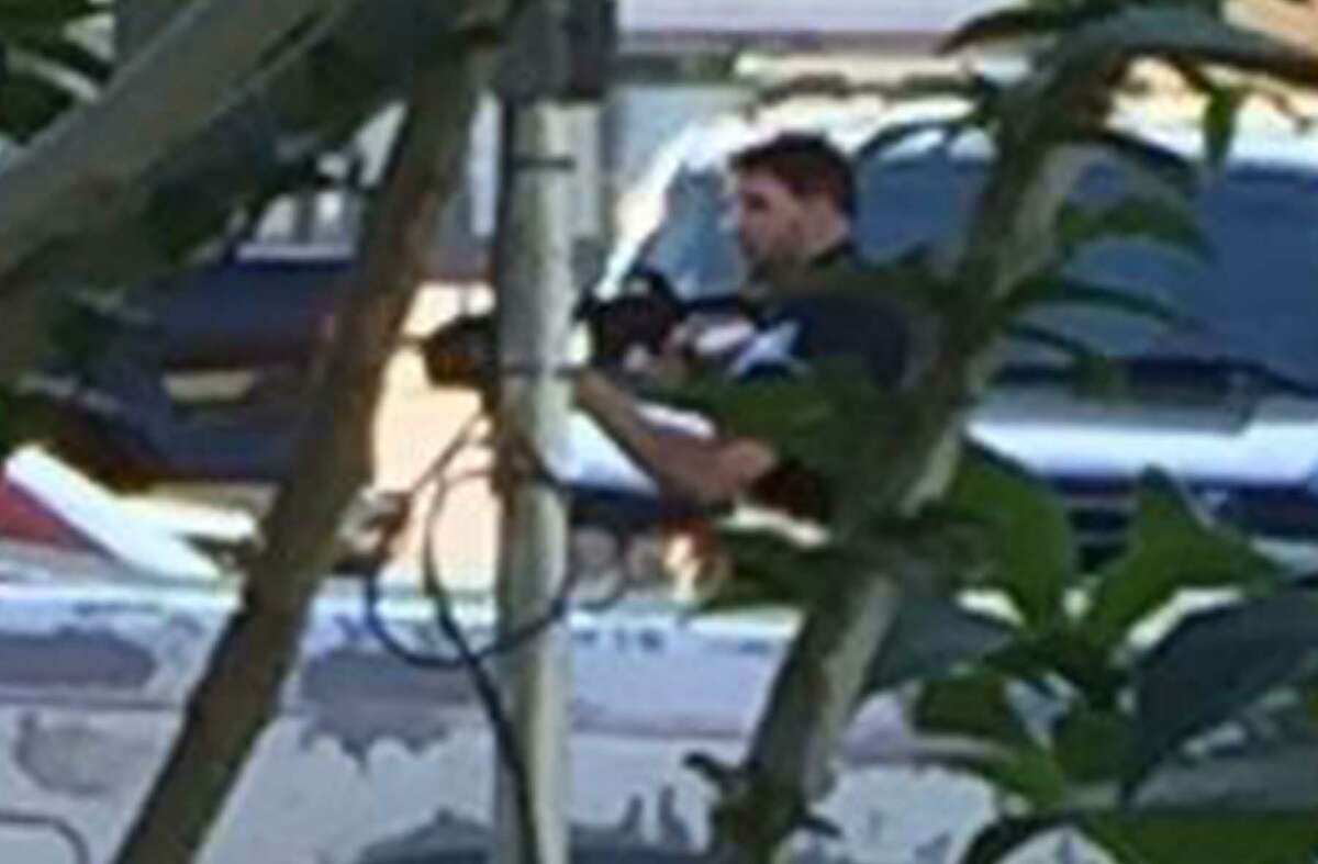 Enlargement of the previous photo showing Beaumont Police officer Chase Welch carrying a rifle toward Herby Balance's home during a March incident where Welch shot and killed Ballance. The photo was taken by a Ballance family member from behind a bush. Photo provided by Richard Waits