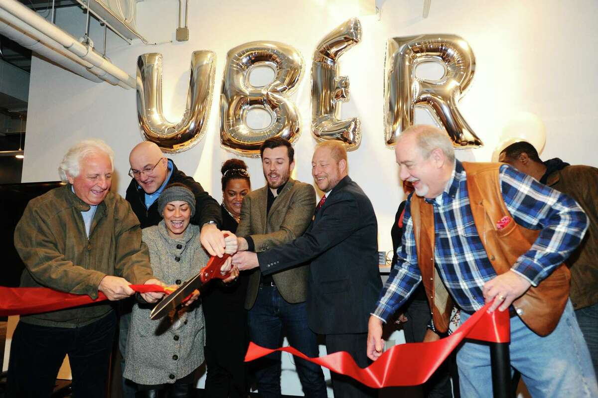 Uber General Manager Matt Powers, center, leads the ribbon cutting for the new Greenlight Hub for Uber driver-partners in Stamford, Conn. on Tuesday, Feb. 7, 2017.