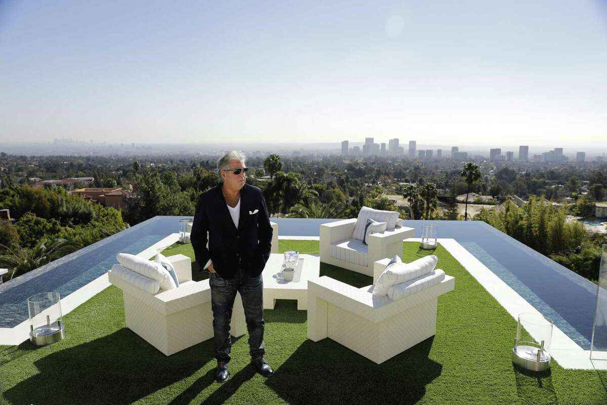Developer Bruce Makowsky poses for a photo on the balcony off the master bedroom of a $250 million mansion he built in the Bel-Air area of Los Angeles. The mansion includes 12 bedroom suites, 21 bathrooms, five bars, three gourmet kitchens, a spa and an 85-foot infinity swimming pool with stunning views of Los Angeles.