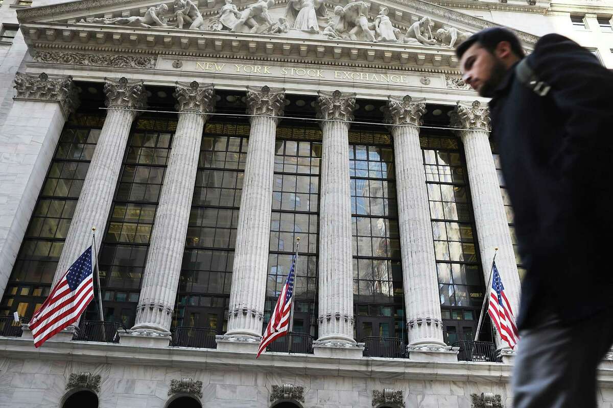 People walk by the New York Stock Exchange. Securities and Exchange Commission investigators believe the NYSE violated the law during a 3 ½-hour outage on July 8, 2015, which froze one of the world’s biggest financial markets.
