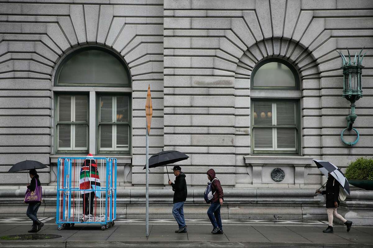 Pedestirans walk past an art piece outside of the Ninth Circuit Court of Appeals which will be hearing the travel ban case this afternoon, in San Francisco, California, on Tuesday, Feb. 7, 2017. The art piece is a caged figure covered in the seven flags of the countries that are currently being banned from entering the United States. The artist (who wished to remain anonymous) said he made the piece from "found objects".
