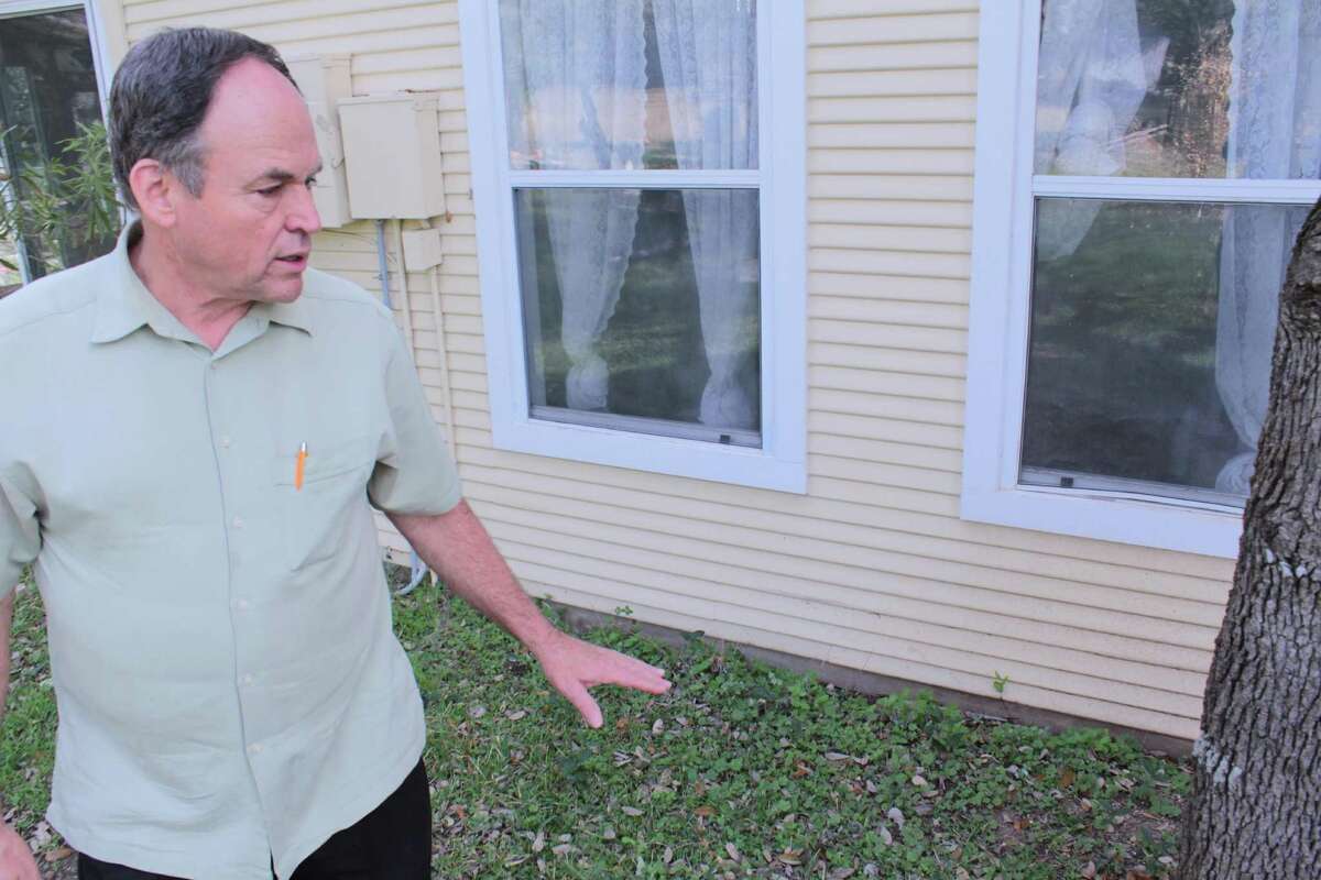 Lavoin Keith Allison shows the water line on his house off of Boerne Stage Road where a San Antonio Water System main break on Jan. 14 caused severe flooding. Allison said repairs could cost of up $50,000, while SAWS is offering only to pay $2,500.