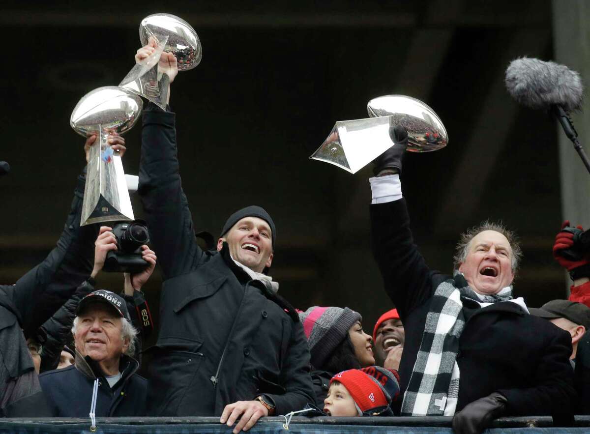 New England Patriots quarterback Tom Brady holds up Super Bowl trophies along with head coach Bill Belichick, right, and team owner Robert Kraft, left, during a rally Tuesday, Feb. 7, 2017, in Boston, to celebrate Sunday's 34-28 win over the Atlanta Falcons in the NFL Super Bowl 51 football game in Houston. (AP Photo/Elise Amendola)
