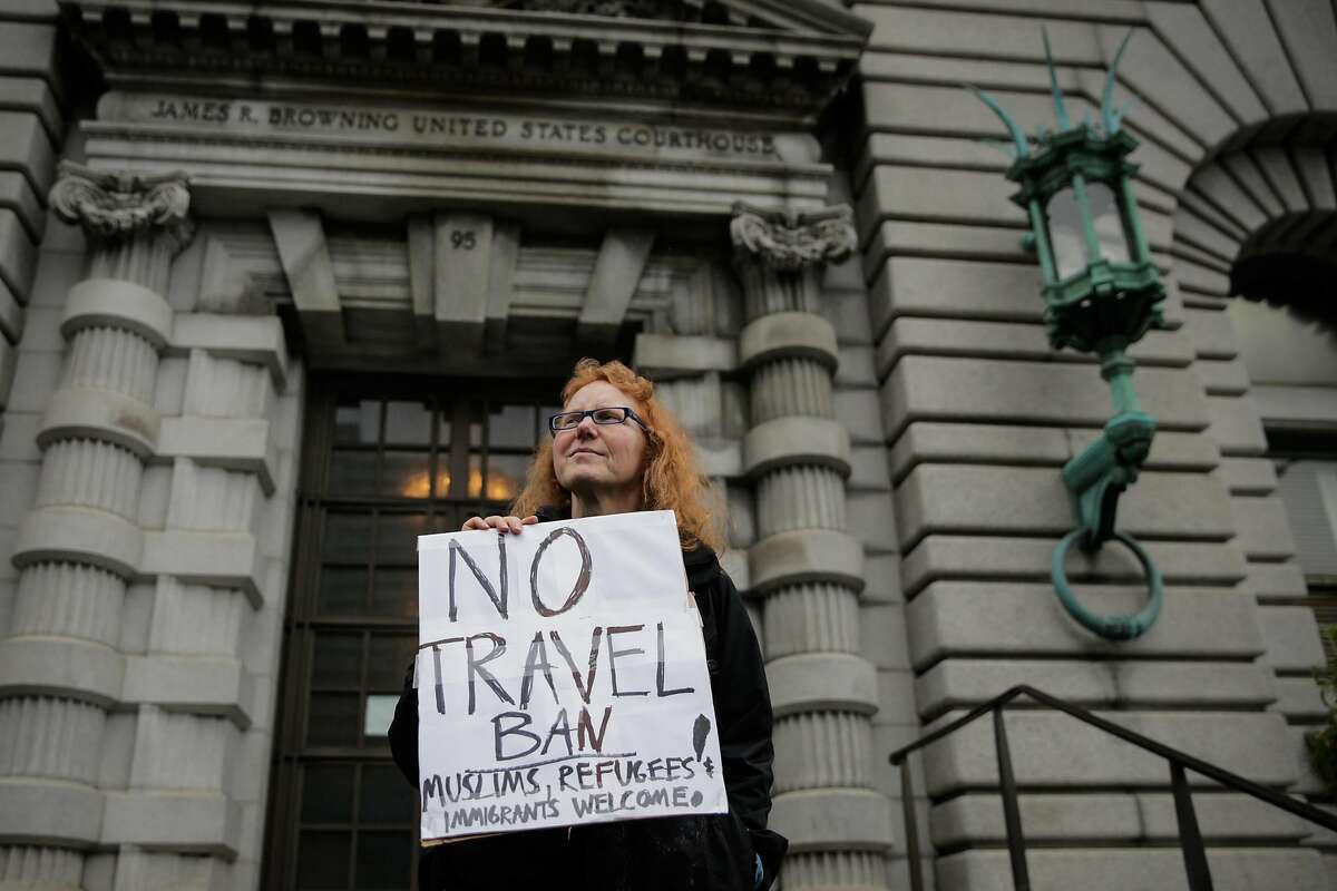 Demonstrator Beth Kohn (center) protests President Donald Trump's travel ban while standing in front of the Ninth Circuit Court of Appeals which is hearing the travel ban case today in San Francisco, California, on Tuesday, Feb. 7, 2017.