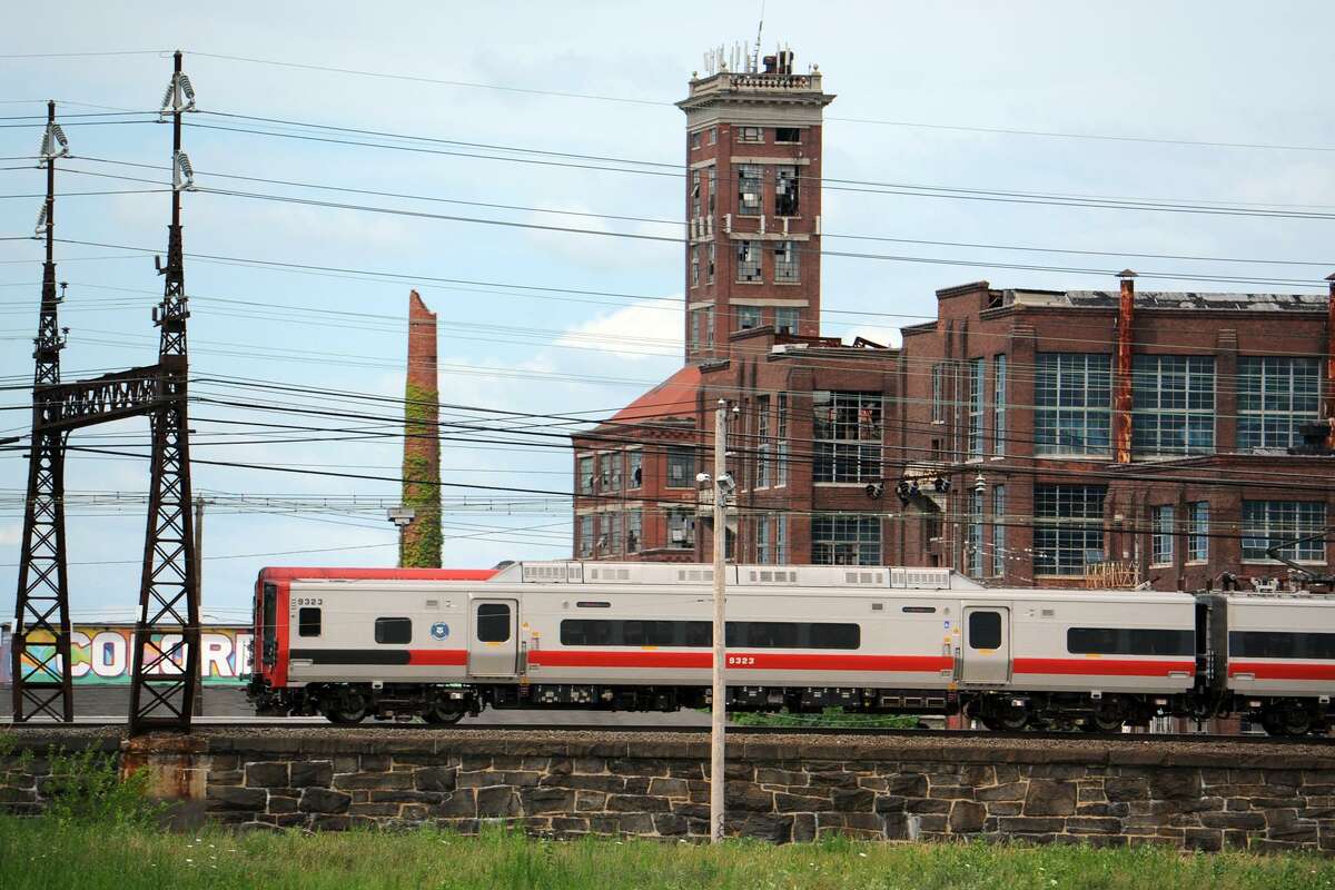 A Metro-North train travels past the former Remington Arms factory, and Shot Tower, in Bridgeport. A new commuter rail station is planned near this location, tentatively called Barnum Station.