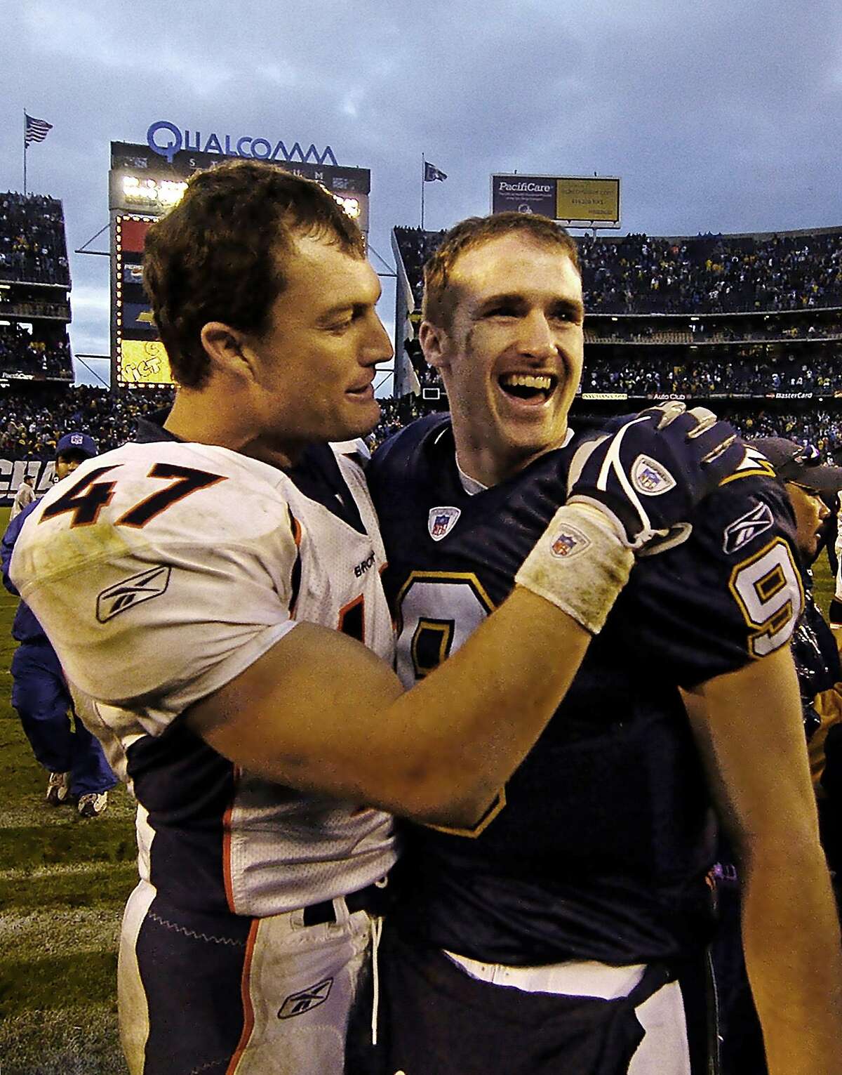 San Diego Chargers quarterback Drew Brees, right, is hugged by Denver Broncos John Lynch after the Chargers 20-17 victory Sunday Dec. 5, 2004 in San Diego. (AP Photo/Denis Poroy) HOUCHRON CAPTION (12/23/2004) SECSPTS: BREES.