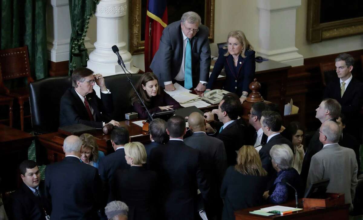 Senators gather around Lt. Gov. Dan Patrick, left, during a point of order as the Texas Senate debates a contentious "sanctuary cities" proposal that would compel local police to enforce federal immigration laws and is on track to be the first piece of legislation passed by either chamber this session, Tuesday, Feb. 7, 2017, at the Texas Capitol in Austin, Texas. (AP Photo/Eric Gay)