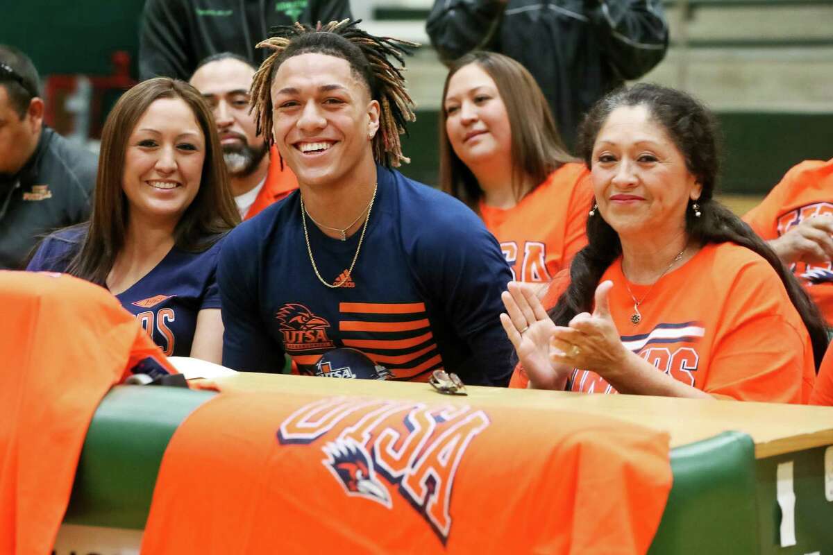 Southwest's Robert Fuentes smiles after signing his letter of intent to play football at UTSA in the Southwest gym seated next to his grandmother, Evelyn Moreno (right) and his mother, Iliana Estrada, on Wednesday, Feb. 1, 2017. MARVIN PFEIFFER/ mpfeiffer@express-news.net