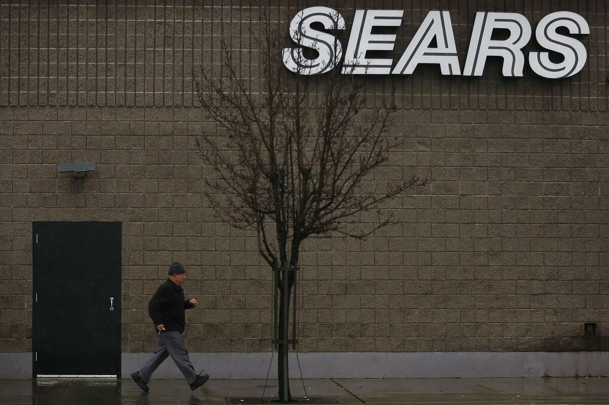 A man jogs to his car in the pouring rain outside of a Sears Automotive Center Feb. 9, 2017 in Richmond Calif.