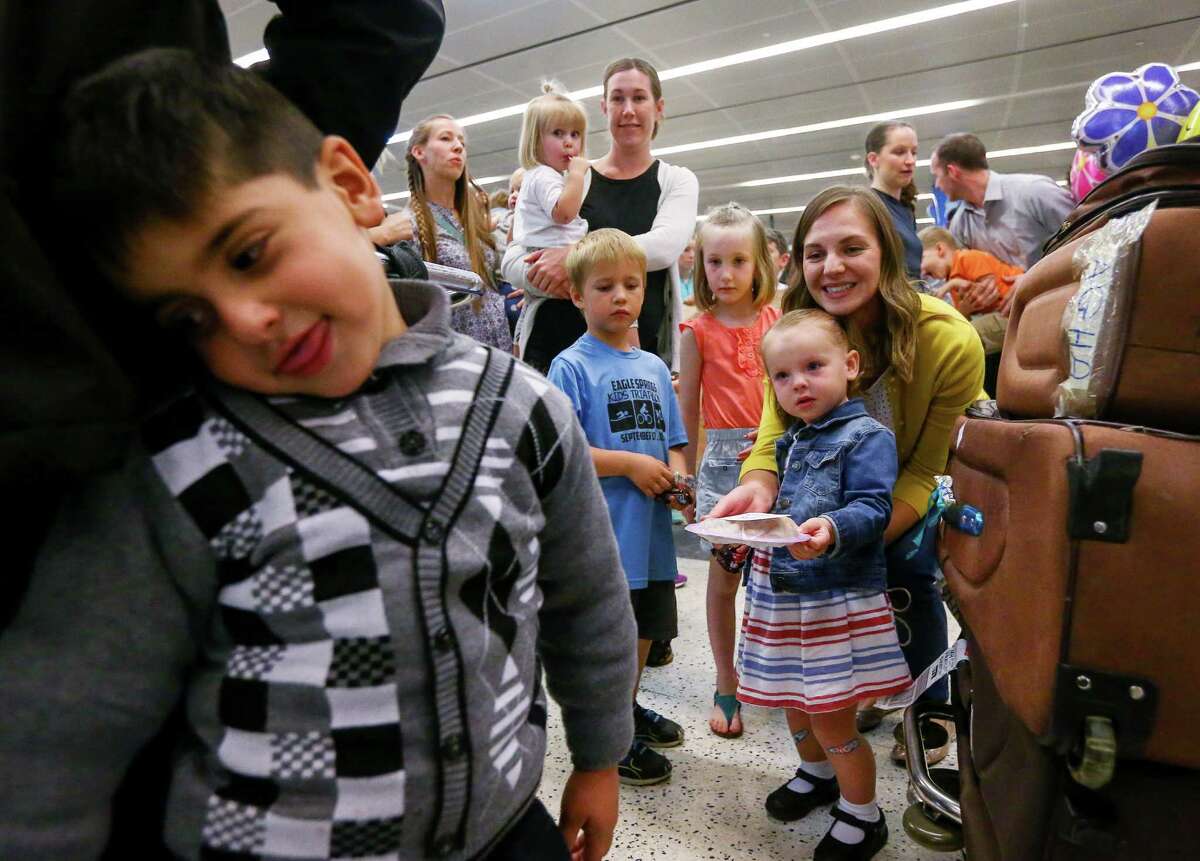 Well-wishers from the Church of Latter-Day Saints offer desserts to one of Noor's seven children, as they greet the family at Bush IAH. The trip came amid the travel ban, but Noor's sponsors said it was not affected by the executive order. ﻿
