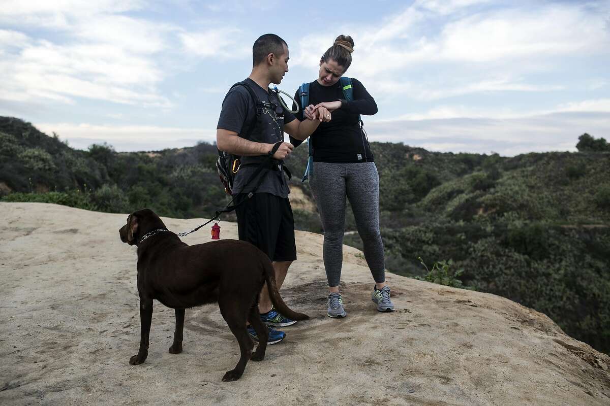 Kevin and Crystal Mo-Wong check their fitness activity on their Fitbit's while hiking the Fullerton Loop hiking trail on February 9, 2017 in Fullerton, Calif. The couple says their Fitbit's have added a layer to the relationship, encouraging them to work out together and talk about their daily activity.