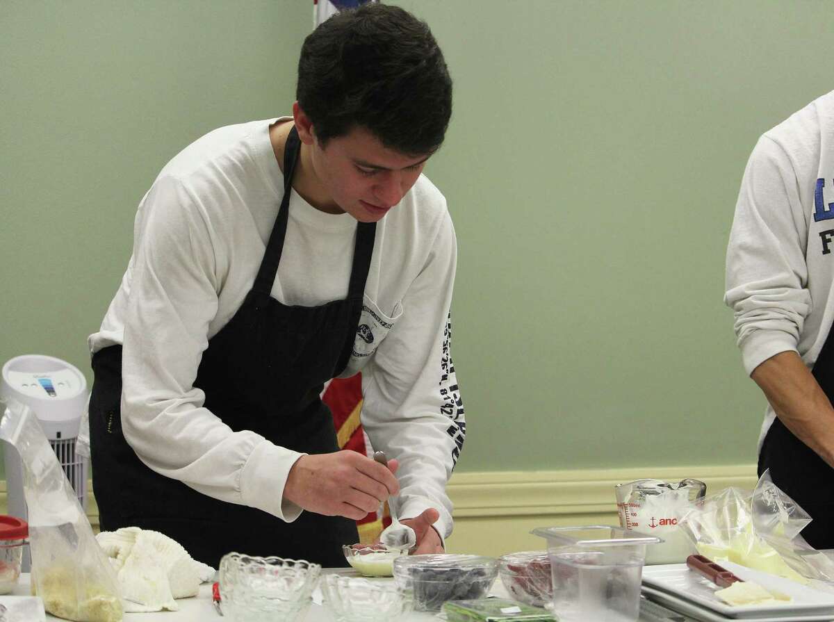 Fairfield Ludlowe High School senior Will Russo finishes off a vanilla custard yogurt parfait at the Fairfield Public Library on Tuesday. He is among students that run Falcon’s Nest, the high school's student-run restaurant and catering service.