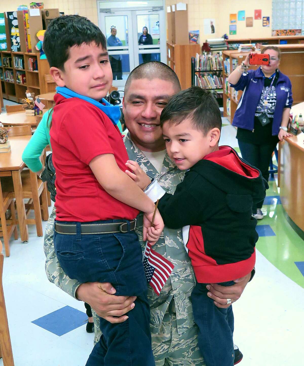 U.S. Air Force Technical Sgt. Jesus Garza, who has been serving overseas, shares a moment with his two children, Jesus Emiliano, 8, and Jesus Alejandro, 3, at their school Thursday. Garza had not seen his children since last summer and surprised them in the Ryan Elementary library, where students also thanked him for his service in the military. According to Laredo ISD, Garza had been stationed in Turkey.