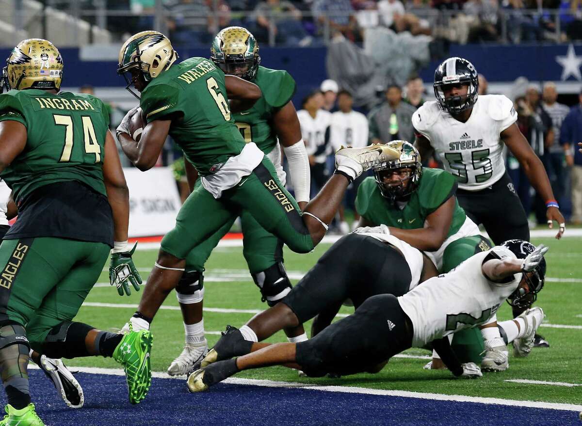 DeSoto's Kelan Walker leaps over Steele defenders for a touchdown in the Class 6A Division II state championship football game at AT&T Stadium in Arlington on Saturday, Dec. 17, 2016.