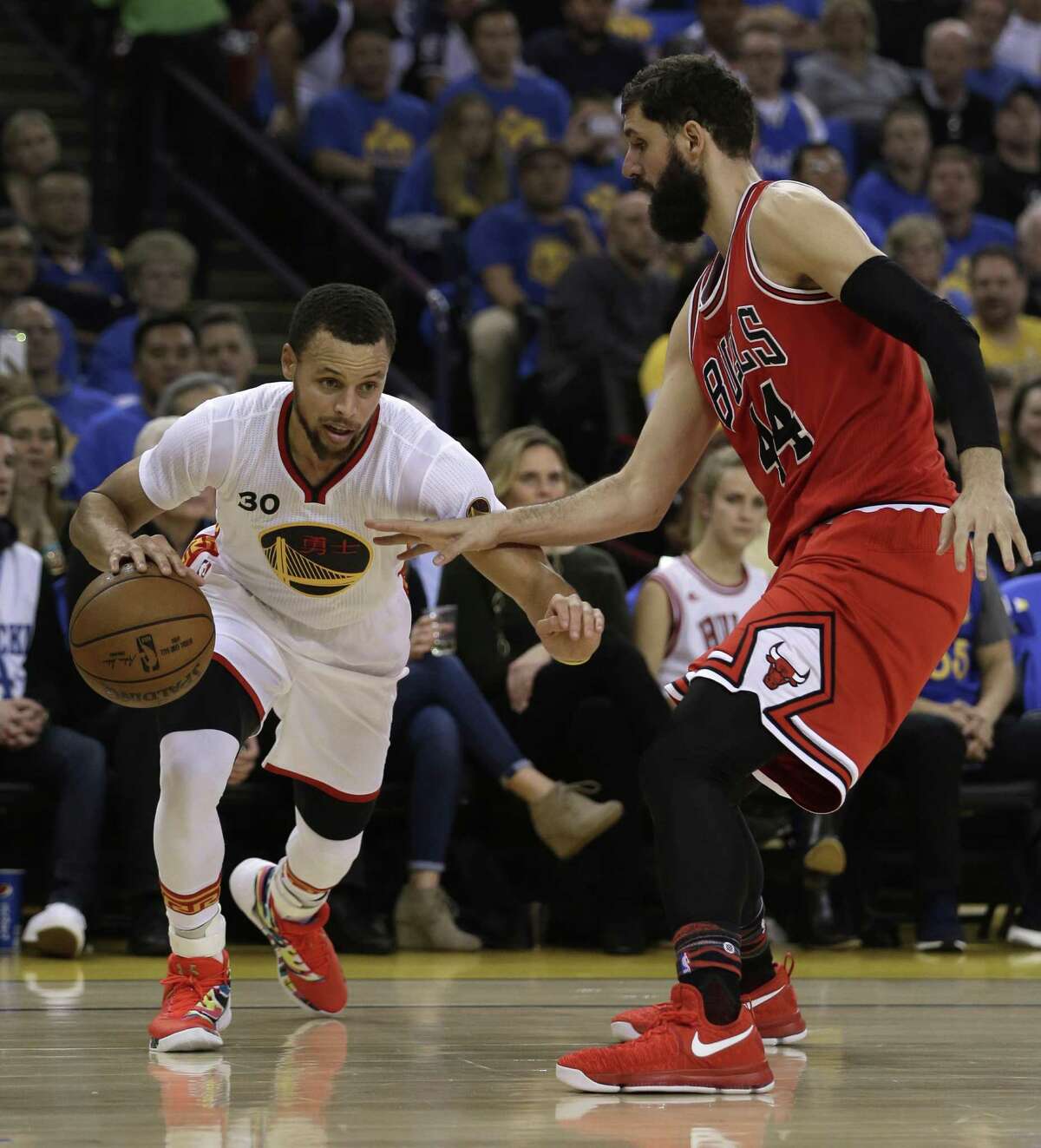Golden State Warriors guard Stephen Curry (left) drives the ball against Chicago Bulls forward Nikola Mirotic during a Feb. 8 game. Curry, Under Armour’s most prized sneaker pitchman, is one of three of the clothing company’s biggest names who has spoken out against CEO Kevin Plank after he publicly praised the Republican president.