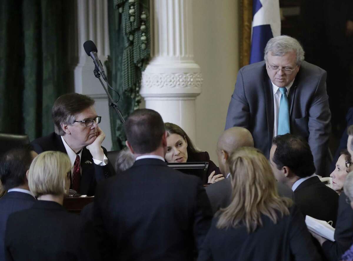 Senators gather around Lt. Gov. Dan Patrick, left, during a point of order as the Texas Senate debates a contentious "sanctuary cities" proposal that would compel local police to enforce federal immigration laws and is on track to be the first piece of legislation passed by either chamber this session, Tuesday, Feb. 7, 2017, at the Texas Capitol in Austin, Texas. (AP Photo/Eric Gay)