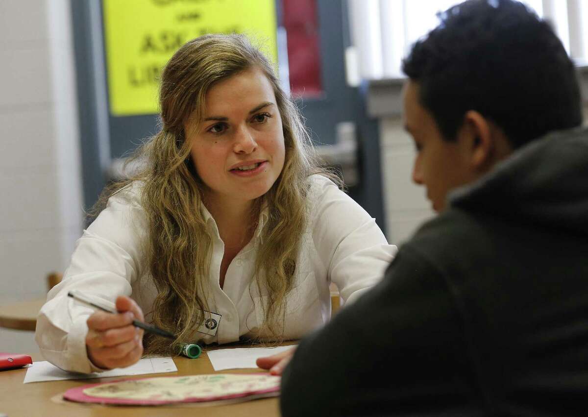 Rhodes Middle School seventh-grade student Reynaldo Guerrero meets with his City Year coach Hannah Van Dolsen (left) to go over grammar as part of the Diplomas Now program on Feb. 9, 2017. The program, a partnership of three national nonprofits that was initially funded by the Obama administration, helps at-risk students in middle and high schools nationwide. Locally, the program exists at Rhodes Middle and Burbank High, both in the San Antonio Independent School District.