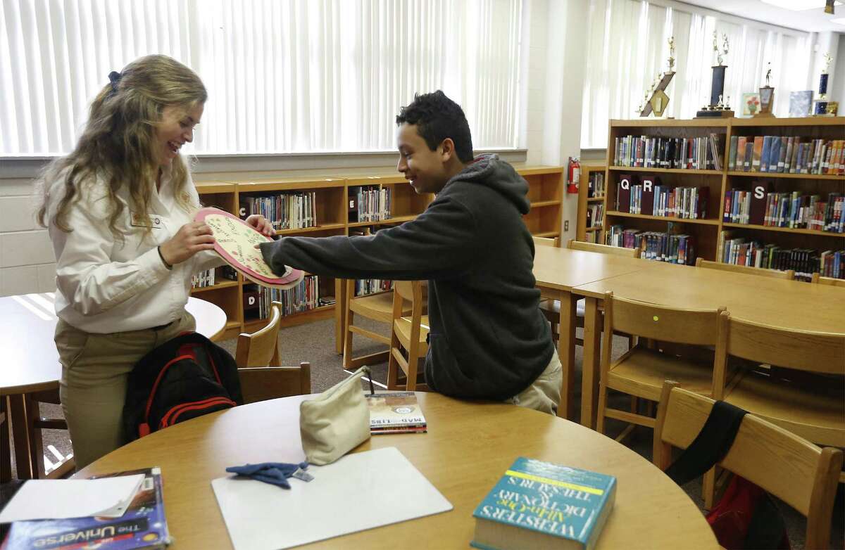Rhodes Middle School seventh-grade student Reynaldo Guerrero (right) is helped by his City Year coach Hannah Van Dolsen as they go over grammar as part of the Diplomas Now program on Feb. 9, 2017. The national program helps students locally at Rhodes Middle and Burbank High, both in SAISD. The district was hoping to expand the program, but federal funding has dried up.