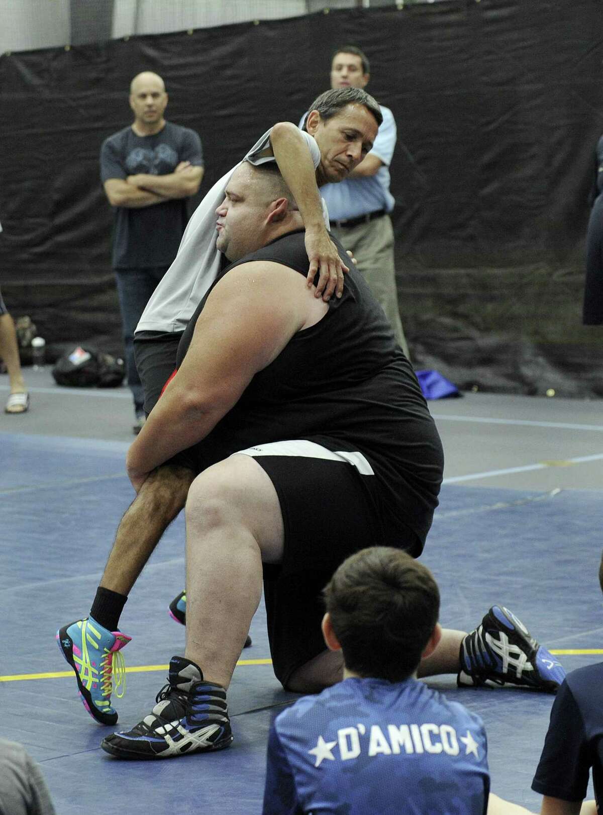 Rulon Gardner, a U.S. Olympic wrestler who won a gold medal in 2000, demonstrates technique with Curtis Urbina, coach for the Newtown Youth Wrestling Assoc. Wednesday, August 17, 2016. Gardner worked with kids at the Newtown Youth Wrestling summer camp at the Newtown Youth Academy Wednesday.