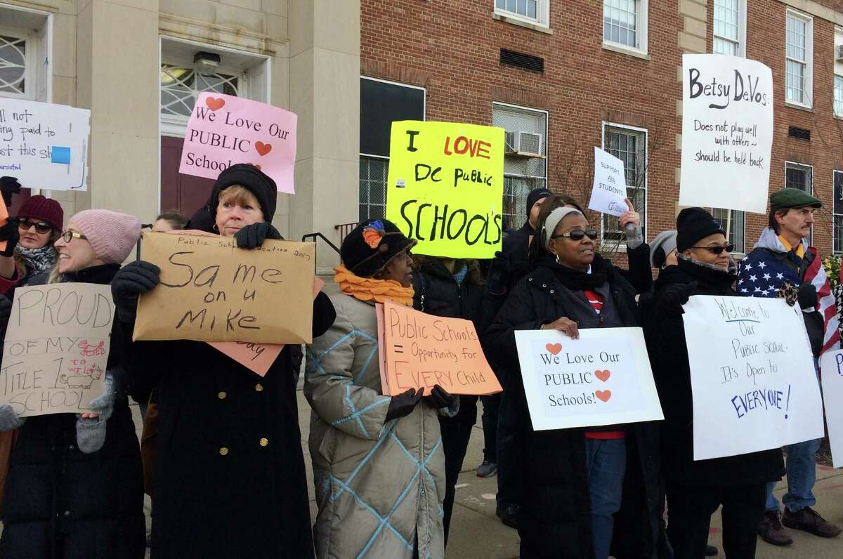 Protesters gather outside Jefferson Middle School in Washington, Friday, Feb. 10, 2017, where Education Secretary Betsy DeVos paid her first visit as education secretary in a bid to mend fences with educators after a bruising confirmation battle. (AP Photo/Maria Danilova)
