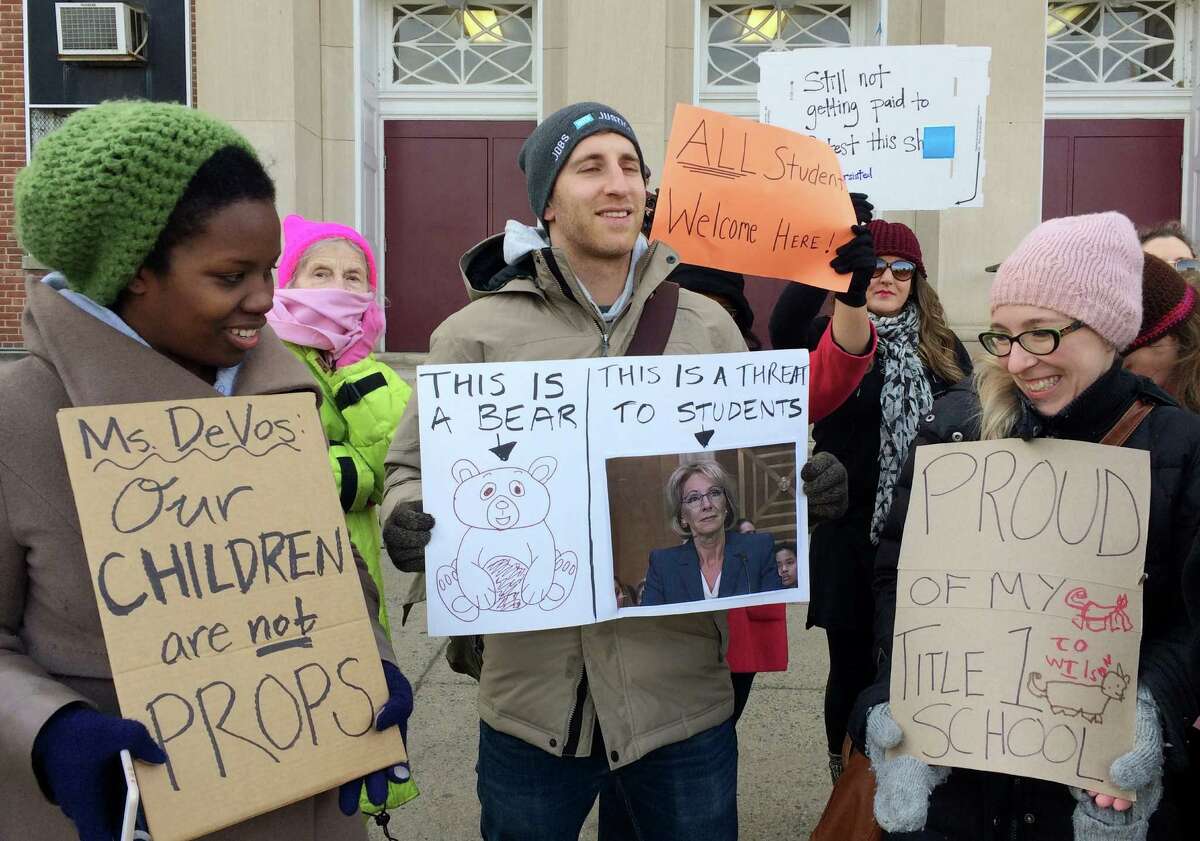 Protesters, including Ari Schwartz, center, gather outside Jefferson Middle School in Washington, Friday, Feb. 10, 2017, where Education Secretary Betsy DeVos paid her first visit as education secretary in a bid to mend fences with educators after a bruising confirmation battle. (AP Photo/Maria Danilova) /// -----Original Message----- From: Danilova, Maria Sent: Friday, February 10, 2017 11:15 AM To: waspi@ap.org Subject: Devos Protest DQoNCg0KU2VudCBmcm9tIG15IGlQaG9uZQ==