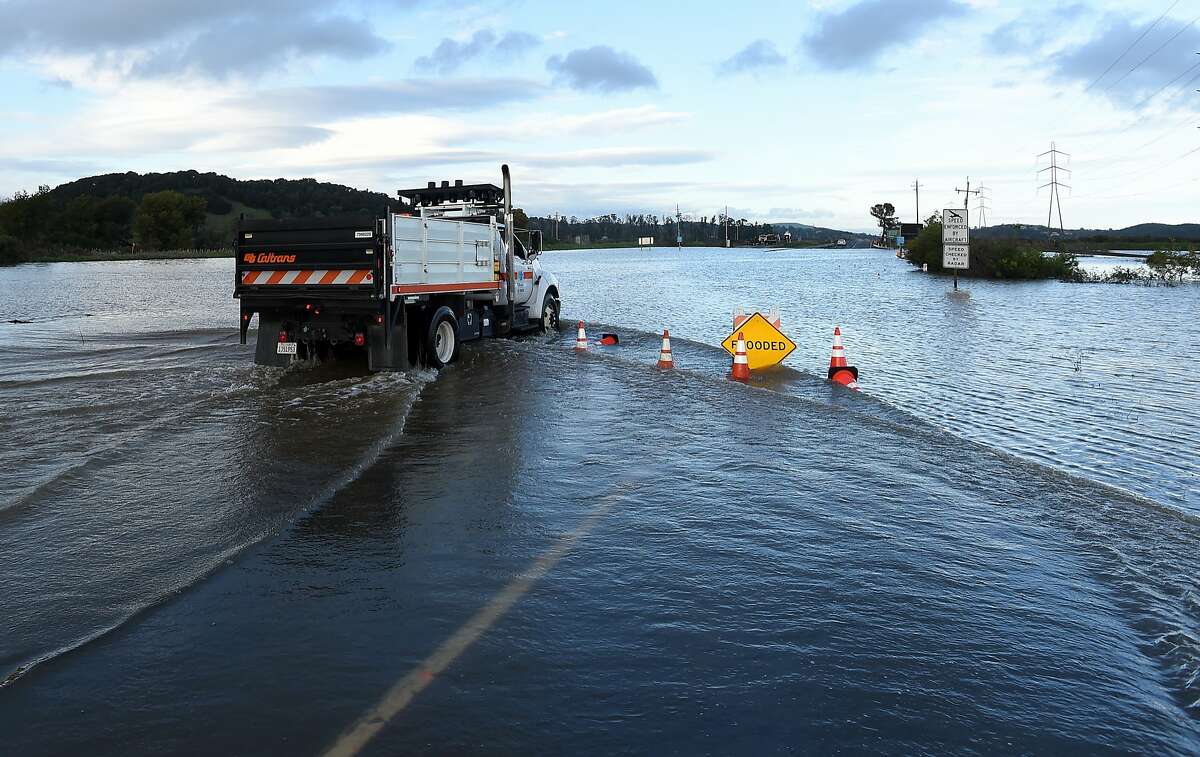 A CalTrans truck drives along a flooded section of Highway 37 in Novato, California on February 10, 2017. The road has been closed at least 14 days this winter due to flooding and extensive rain.
